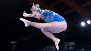 Gymnast mid-leap during a floor routine streaming live on USATVStream