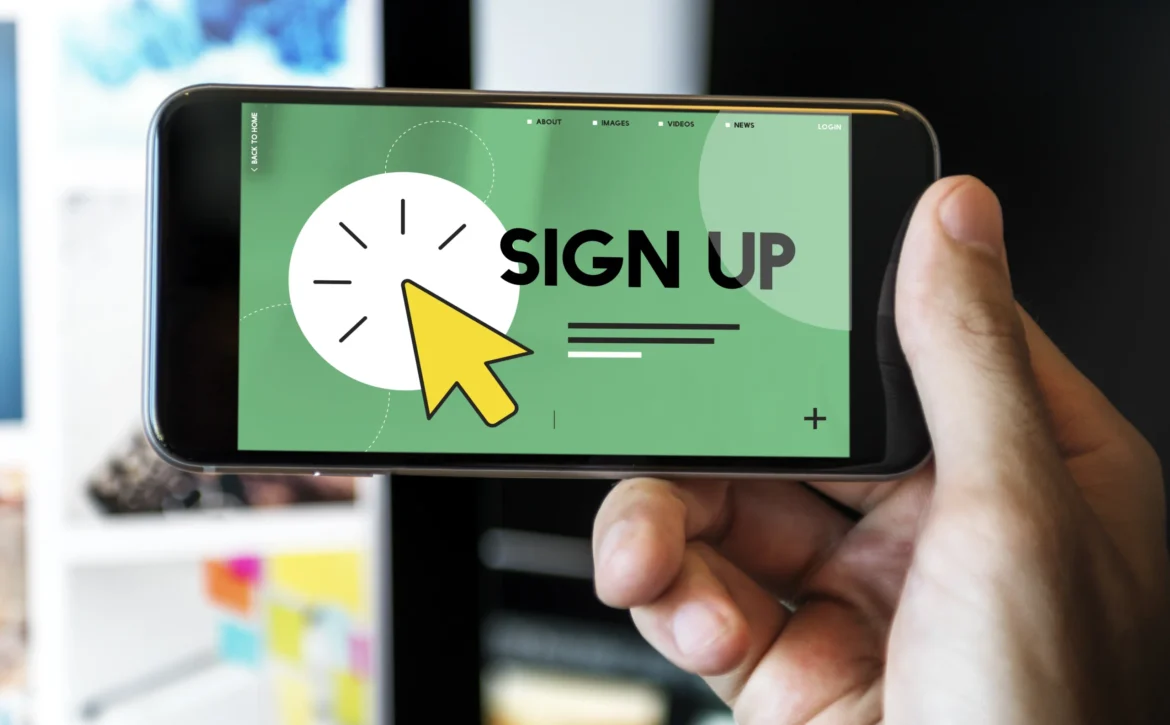 Hand holding a phone showing a sign-up screen