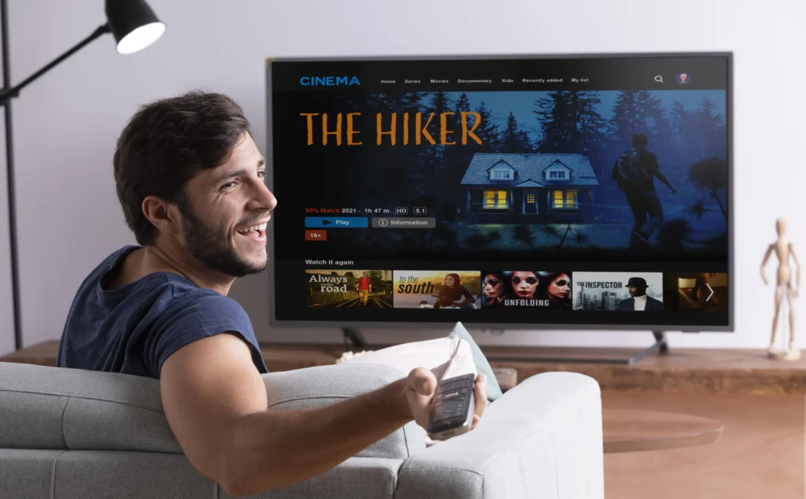 Man browsing a full-screen streaming interface on a smart television